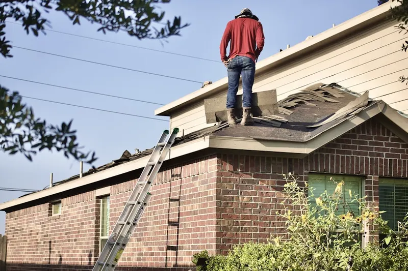 Professional roofer working on a residential roof in Gilpin Manor
